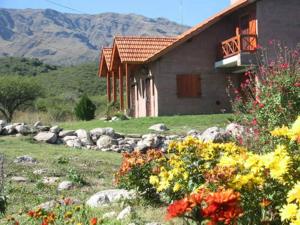 Una casa con un ramo de flores delante de ella. en Cabañas Oma Lissi, en Merlo
