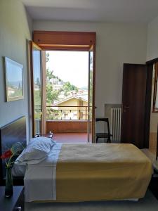 ein Schlafzimmer mit einem großen Bett und einem großen Fenster in der Unterkunft Balcone sul Metauro in Peglio