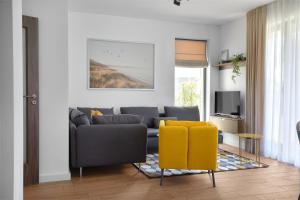 a living room with a couch and a yellow chair at The luxury flat in Ahtopol