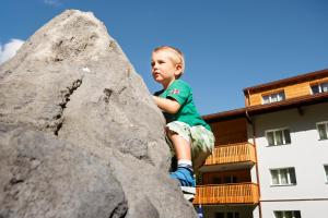 ジナルにあるReka-Feriendorf Zinalの岩の上に座る少年