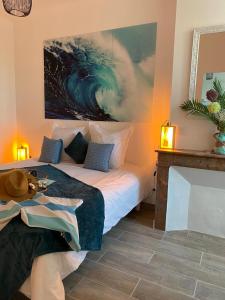 a bedroom with a bed and a painting on the wall at Le Logis de Virginie in Rochefort