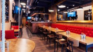 a restaurant with wooden tables and red chairs at AX The Saint John in Valletta