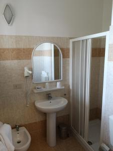 ein Bad mit einem Waschbecken, einer Dusche und einem Spiegel in der Unterkunft Balcone sul Metauro in Peglio