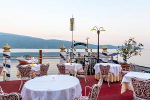 restauracja na statku wycieczkowym ze stołami i krzesłami w obiekcie Hotel Baia D'Oro - Adults Only w mieście Gargnano