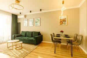 a living room with a green couch and a table at Lago Apartment Mamaia Butoaie in Mamaia