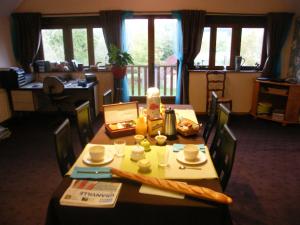 a dining room with a table with chairs and a tableablish at La Ferme de Montaigu in Montaigu-les-Bois