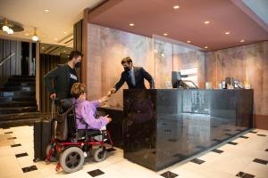 a woman in a wheelchair in front of a counter at Regente Hotel in Madrid