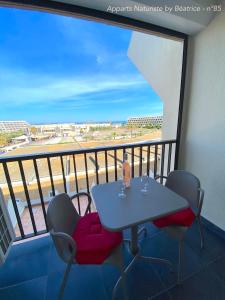 a table and chairs on a balcony with a view at Studios Héliopolis Village Naturiste in Cap d'Agde