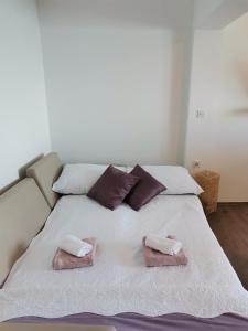 a bed with two towels on top of it at Apartman Sunset in Sutomišćica