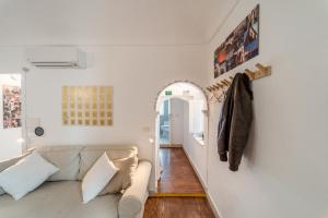 ein Wohnzimmer mit Sofa und Flur in der Unterkunft Ortigia Colourful Apartment in Syrakus