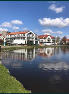 a group of buildings next to a body of water at Apartament Mazury Mrągowo nad jeziorem. in Mrągowo