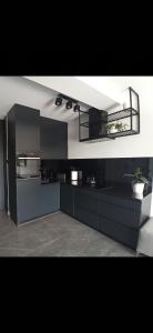 a large kitchen with black cabinets and a mirror at Apartament Mazury Mrągowo nad jeziorem. in Mrągowo