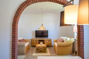 an archway in a living room with a couch and a tv at Ferienhäuser Rosalinn und Felinchen in Eutin