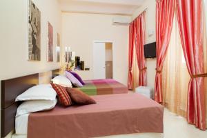 ローマにあるDeseo Depandanceのベッドルーム1室(赤いカーテン付きのベッド2台付)
