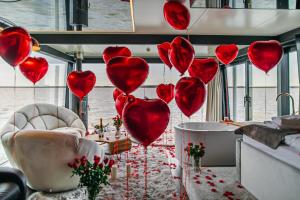 a bunch of red heart balloons in a room at Domki na wodzie - Grand HT Houseboats - with sauna, jacuzzi and massage chair in Mielno