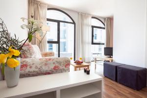 una sala de estar con sofá y un jarrón de flores en Inside Barcelona Apartments Sants, en Barcelona