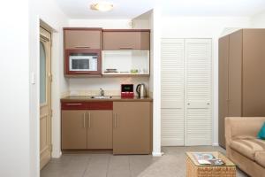 a small kitchen with a sink and a microwave at Tresori Motor Lodge in Akaroa