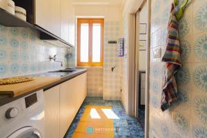 a kitchen with a washer and dryer in a room at BLUE HOUSE - SAN FOCA in San Foca