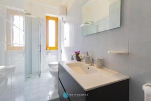 a white bathroom with a sink and a toilet at BLUE HOUSE - SAN FOCA in San Foca