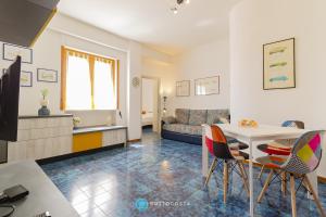 ein Wohnzimmer mit Tisch und Stühlen und einer Couch in der Unterkunft BLUE HOUSE - SAN FOCA in San Foca