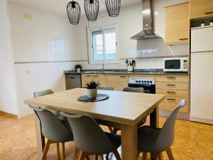 a kitchen with a wooden table and chairs at Sa Tuna - Delta de l'Ebre in Riumar