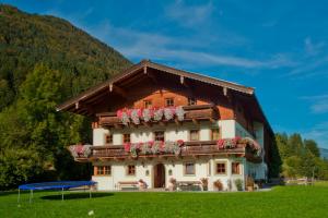 a house with flowers on the front of it at Appartements Binderhof in Kirchdorf in Tirol