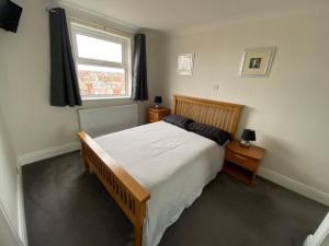a bedroom with a large bed and a window at The Royal Court Apartments in Bridlington