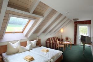 a hotel room with a bed and a window at Landhotel Rittersgrün in Breitenbrunn