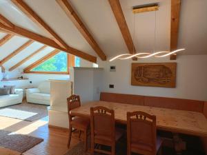 cocina y comedor con mesa de madera y sillas en Fiemme Deluxe Apartment, en Castello di Fiemme