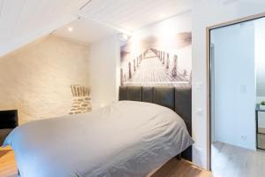 ein Schlafzimmer mit einem weißen Bett und einer Treppe in der Unterkunft Bel Even in Plouër-sur-Rance