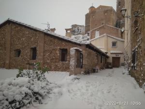 una calle cubierta de nieve junto a un edificio en La Casa Gran, en Castielfabib