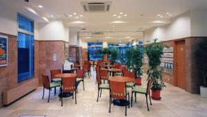 una sala da pranzo con tavoli, sedie e piante di Toyoko Inn Tokyo Ikebukuro Kita-guchi No.1 a Tokyo