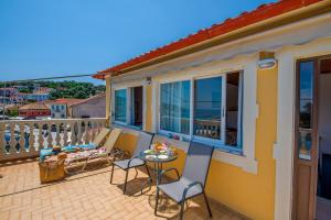 een balkon met een tafel en stoelen en uitzicht op de oceaan bij "OceanBreeze'' Studio in Gaios