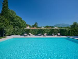 una piscina con sillas y sombrillas en Cason degli Ulivi, en Rivoli Veronese