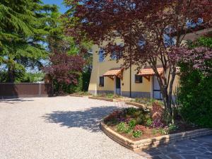een gebouw met een boom en bloemen op een binnenplaats bij Cason degli Ulivi in Rivoli Veronese