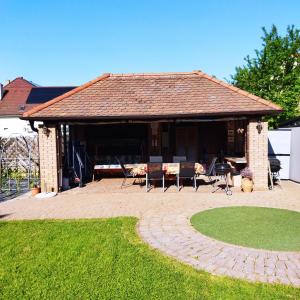 a house with a pavilion with chairs and a lawn at The Boys Apartman in Siófok