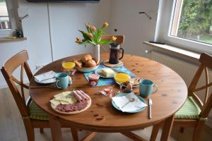 uma mesa de madeira com comida para o pequeno almoço em Ferienhaus Untere Zeitelwaidt em Bad Steben