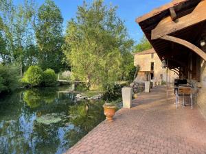 a patio with a view of a river at Le Petit courault in Pamproux