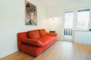 an orange couch in a living room with a window at Ferienhaus Untere Zeitelwaidt in Bad Steben