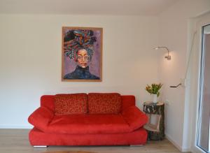 a red couch in a living room with a painting at Ferienhaus Untere Zeitelwaidt in Bad Steben +30 photos