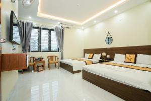 a hotel room with two beds and a television at HOẰNG MINH HOTEL in Sầm Sơn +44 photos