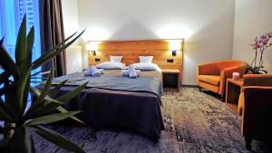グジボボにあるAmberiaのベッドと椅子付きのホテルルーム