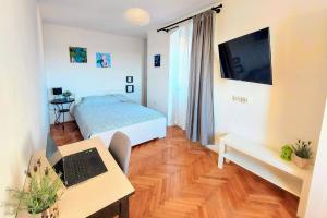 a bedroom with a bed and a desk with a laptop at Casa di Castello in Mali Lošinj