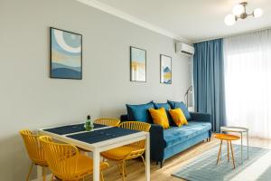 ein Wohnzimmer mit einem blauen Sofa und einem Tisch in der Unterkunft Lucky 13 in Mamaia