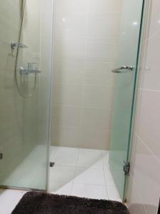 a bathroom with a shower with a glass door at Josh's Place at One Eastwood Avenue Tower 1 in Manila