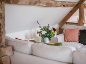 奇平諾頓的住宿－Hayloft at NewBarn Farm，客厅配有沙发和鲜花,桌子上