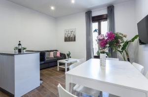 un soggiorno con un tavolo bianco e un divano di Doña Blanca Centro Diseño Minimalista a Jerez de la Frontera