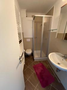a bathroom with a shower and a toilet and a sink at Entspann you in Wangerland +11 photos