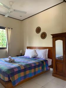 een slaapkamer met een bed met een knuffeldier erop bij Rama Homestay in Ubud