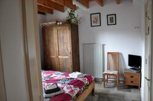 a bedroom with a bed and a desk and a television at B&B Kelpiebrink in Baarle-Nassau